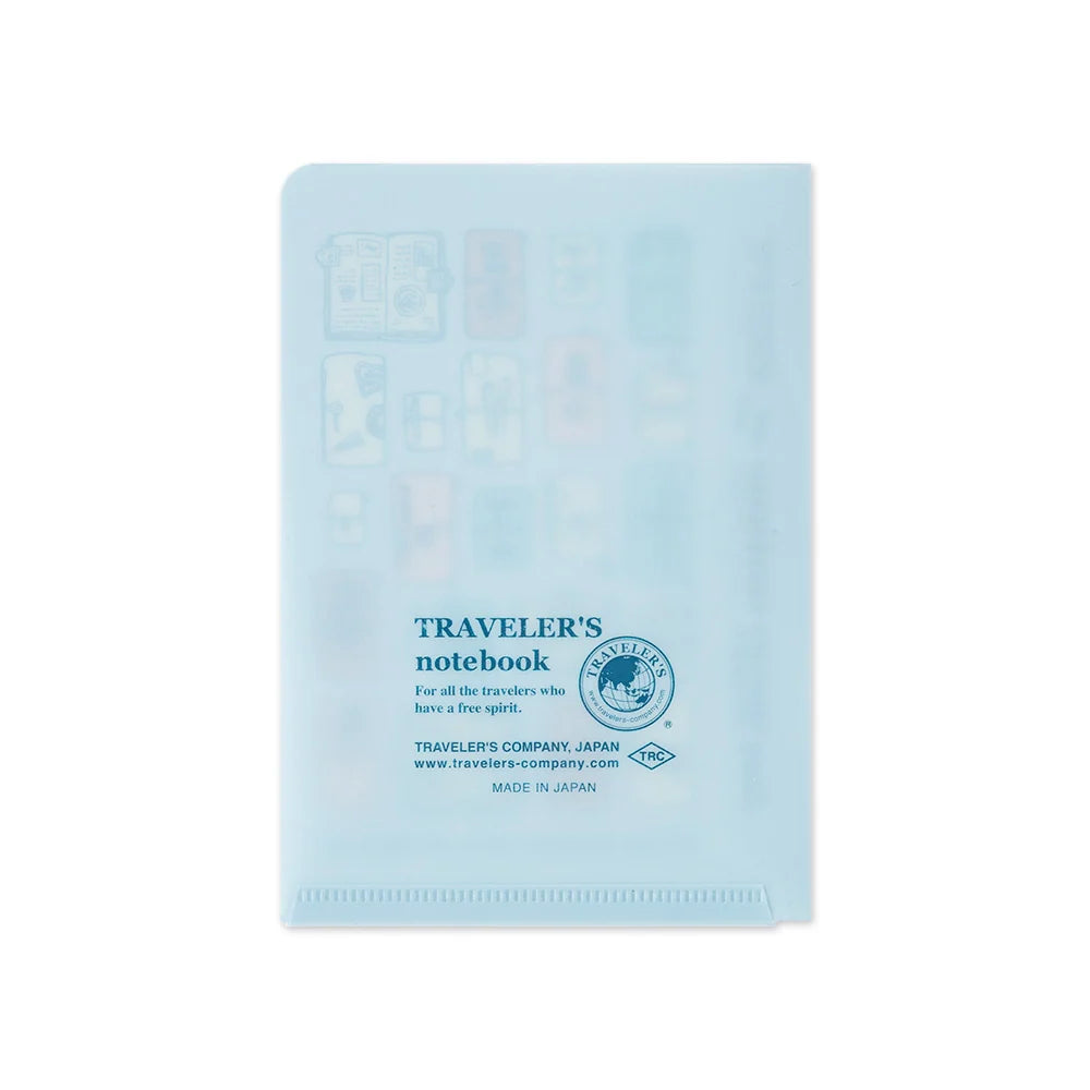 A light blue translucent plastic notebook cover with travel icons and printed blue text reading 'TRAVELER'S notebook' and 'Traveler's Company, Japan' on a white background.