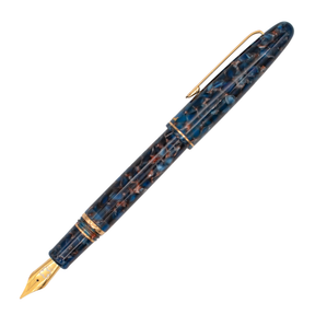 Navy blue marble abstract fountain pen with the cap posted on the barrel with gold trim accents on a plain white background.