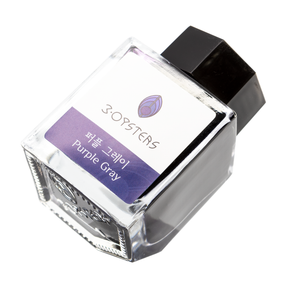 3 Oysters Purple Gray from the Delicious collection is a dark cool-tone purple fountain pen ink with low shading. It dries in 30 seconds in a medium nib on Rhodia and has a dry flow. The glass bottle has a cut out corner to lean the bottle for a decorative display. 3 Oysters ink is made in Korea.  Pantone color: 5275C